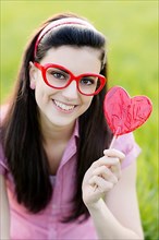 Woman with glasses and heart lolly,
