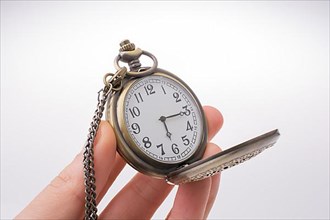 Retro style pocket watch in hand on white background,