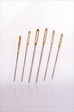 Six different sewing needles isolated on a white background,