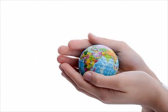 Child holding a small globe in hand on white background,