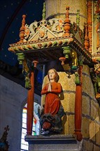Enclos paroissial, Praying woman on fancy monster to the left of the rood screen
