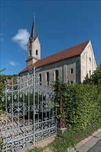 Wrought-iron gate of the cemetery, in the back the neo-Gothic St. Catherine's Church