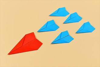 Red paper airplane leading blue airplanes. Concept for discovery and leadership,