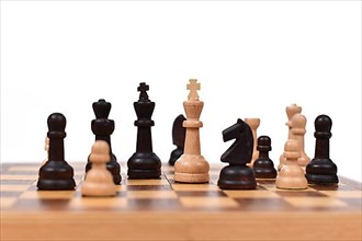 Chess board game with focus on white queen pieces on white background,