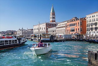 Water taxi in front of the waterfront with Doge's Palace, Campanile and Hotel Danieli