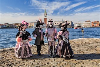 Carnival masks in front of the panorama of the city with Campanile and Doge's Palace, Venice