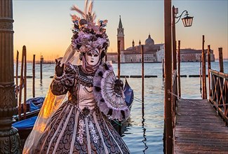 Carnival mask on the waterfront at sunrise, Venice