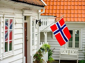 Norwegian flag on white wooden house, Stavanger