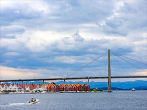 Houses under suspension bridge with shipping traffic, Stavanger