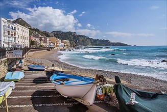 Fishing boats on the beach with sea surf in front of the promenade, Giardini-Naxos