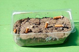 Cigarette butts in a plastic bowl as an ashtray, Germany