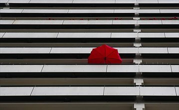 Red parasol on the balcony of a high-rise building in Marzahn, Berlin