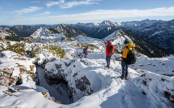 Three mountaineers between snowy karst rocks, hiking to Ammergauer Hochplatte