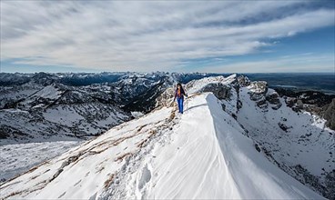 Climber on a rocky snowy ridge, hiking trail to Ammergauer Hochplatte