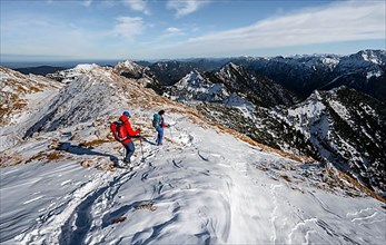 Two mountaineers on the rocky snowy ridge of the Ammergauer Hochplatte, view towards Loesertaljoch