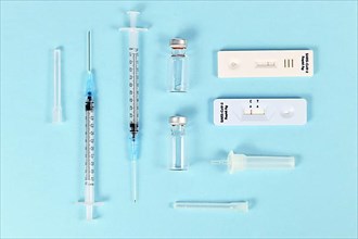 Rapid antigen test and vaccine vials with syringes. Tools to fight Corona Virus pandemic,