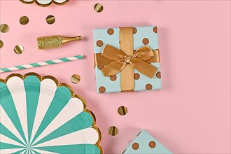 Party flat lay with teal blue paper plates, gift box
