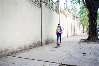 Latin woman walking her dog, both dressed alike. Grey background. Copy space