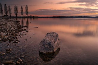 Stone in the water at sunset in Unteruhldingen on Lake Constance, Germany