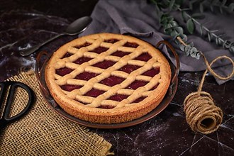 Homemade pie called Linzer Torte, a traditional Austrian shortcake pastry topped with fruit preserves and sliced nuts with lattice design