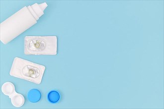 Packs with hazel green colored circle lenses, a type of contact lenses to enlarge eyes and change eye color with storage container and cleaning solution on side of blue background