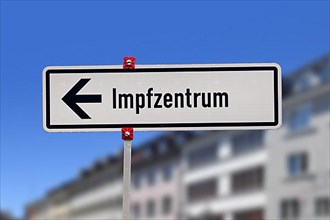 German street sign pointing towards vaccination center called Impfzentrum set up to vaccine people against Corona virus,