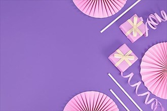 Violet party flat lay with pink gift boxes, paper streamers