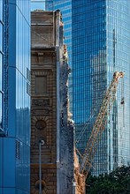 Construction site, crane demolishing historic apartment building