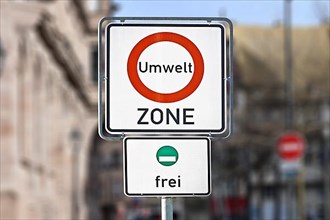 Road traffic sign marking a low emission zone in city centers in Germany translating as Environmental Zone and sign showing cars with green environmental badge a free to enter,