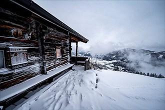 Snowfall, mountain hut in the snow