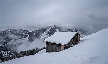 Snowfall, mountain hut in the snow