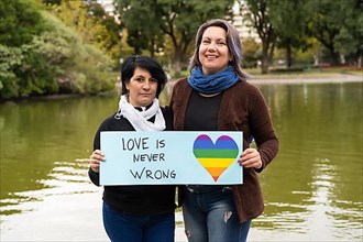 Love is never wrong. Cheerful queer couple holding a message supporting the LGBT community,