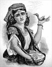 Snake tamer in Cyprus, young woman with a small snake and a drum at a performance