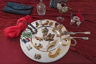 Rhinestone jewellery and accessories decorated on a silver plate and red cloth, Bavaria