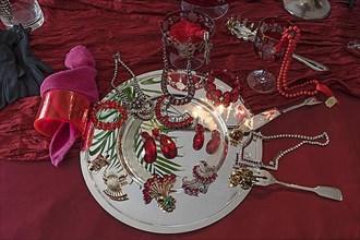 Rhinestone jewellery and accessories decorated on a silver plate and red cloth, Bavaria