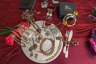 Rhinestone jewellery and accessories decorated on a silver plate and red cloth, Bavaria