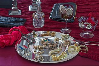 Rhinestone jewellery and accessories decorated on a silver plate and red cloth, Bavaria