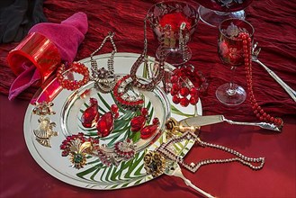 Rhinestone jewellery and accessories decorated on a silver plate and red cloth, Bavaria