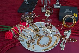 Rhinestone jewellery and accessories decorated on a silver plate and red cloth, Bavaria