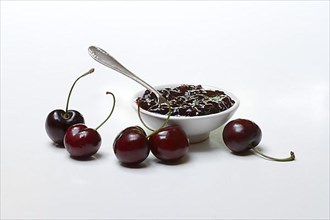 Cherry jam in small bowls and black wild cherry,