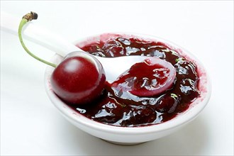 Cherry jam in small bowls and black wild cherry,