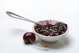 Cherry jam in small bowls and black wild cherry,