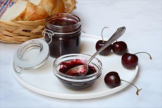Cherry jam in small bowl with spoon, Black cherries