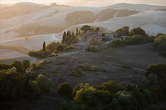 Old country house in the evening light, in hilly landscape of the Crete Senesi