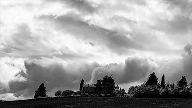 Dark clouds over a country house, black and white photograph