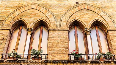 Gothic windows decorated with flower boxes, San Gimignano