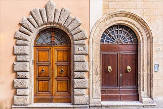 Round arched front doors inlaid with stones and marble, Montepulciano