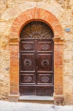 Ornate round arch front door, Montalcino