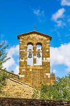 Bell tower against blue sky and white clouds, Montalcino