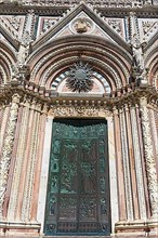 Entrance to the cathedral with the colourful Gothic marble facade, Siena